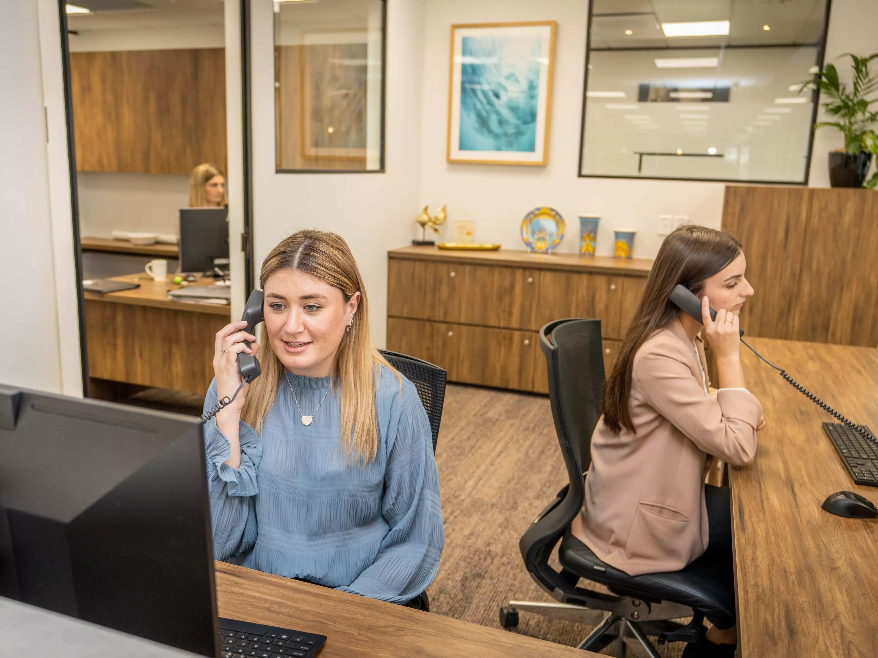Dedicated receptionists helping clients over the phone in the modern coworking space of Servcorp Bell Gully Building, Wellington
