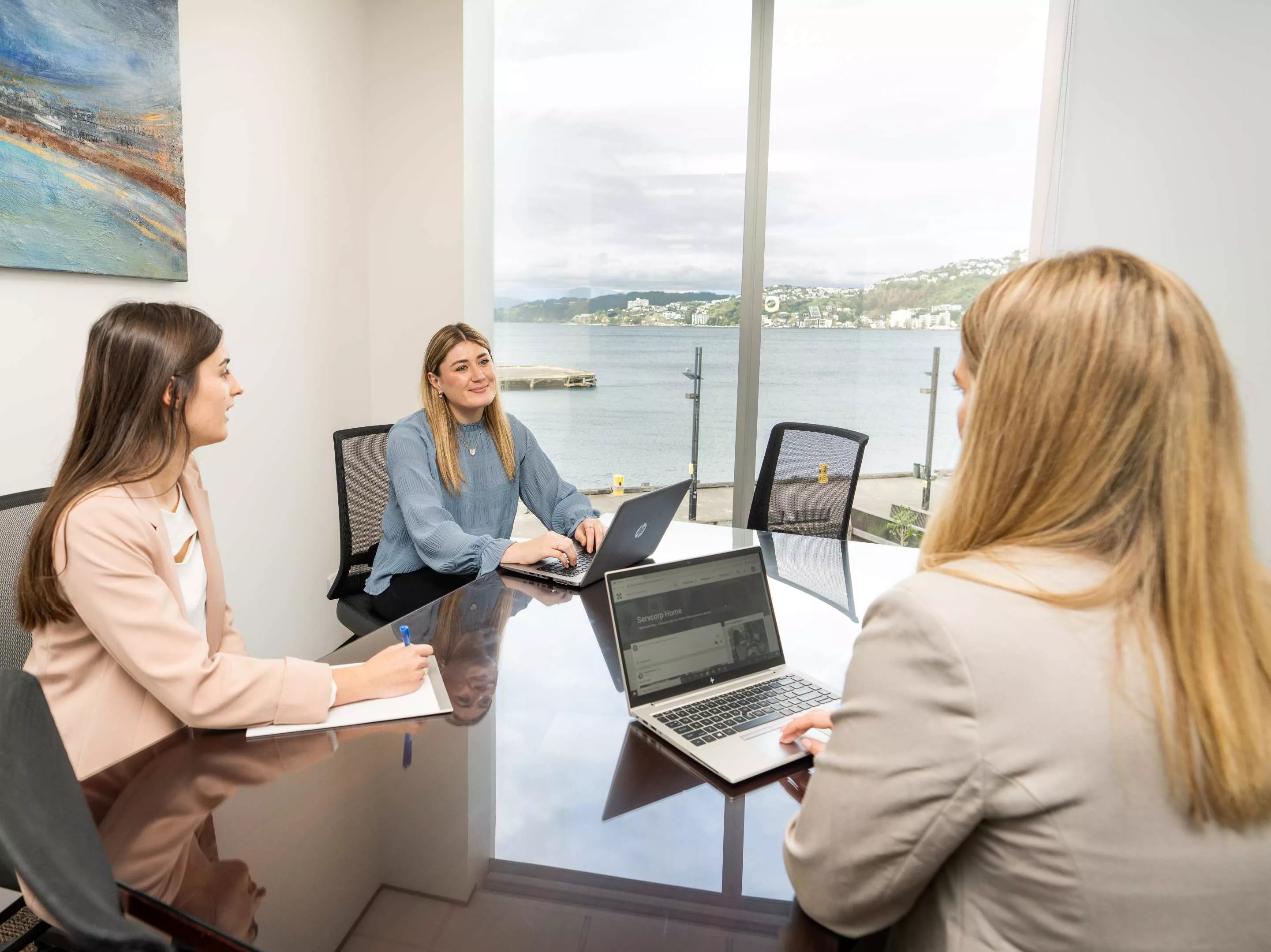 A client talking to her clients working in a modern meeting room space in Servcorp Bell Gully Building, Wellington